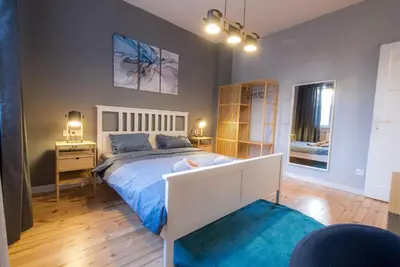 a bedroom with a large bed with a blue bedspread at 35 Seconds Away From the Main Street, Free Secured Parking in Sofia