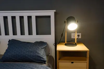 a lamp on a night stand next to a bed at 35 Seconds Away From the Main Street, Free Secured Parking in Sofia