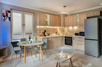 a kitchen with a table and chairs and a refrigerator at Luxury Stays Kapana Plovdiv in Plovdiv