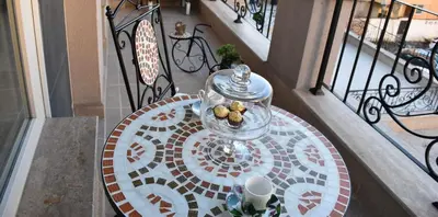 a table with a bowl of food on a balcony at Luxury Stays Kapana Plovdiv in Plovdiv