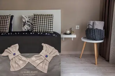 a bedroom with a bed with a chair and a book at Luxury Stays Kapana Plovdiv in Plovdiv