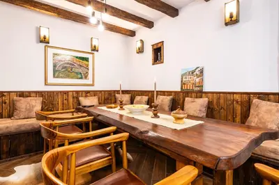 a dining room with a wooden table and chairs at АРТ Къща Широка Лъка in Shiroka Lŭka