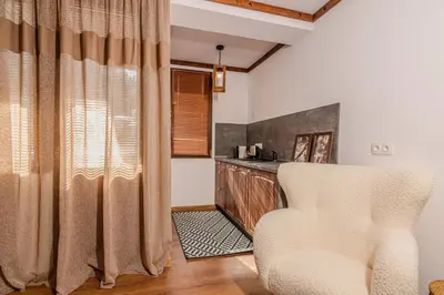 a living room with a chair and a table at АРТ Къща Широка Лъка in Shiroka Lŭka