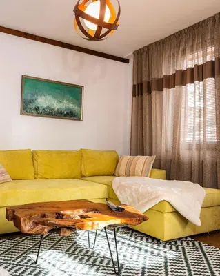 a living room with a yellow couch and a table at АРТ Къща Широка Лъка in Shiroka Lŭka