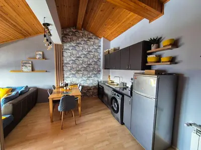 a kitchen with a refrigerator and a table in it at Nordic Sunset Retreat in Pamporovo