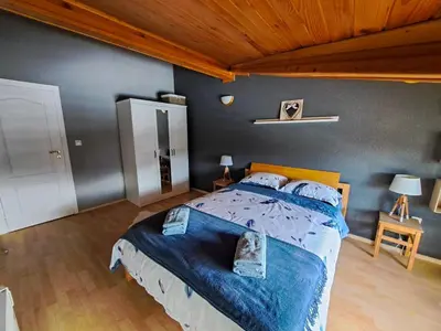a bedroom with a large bed with a blue comforter at Nordic Sunset Retreat in Pamporovo