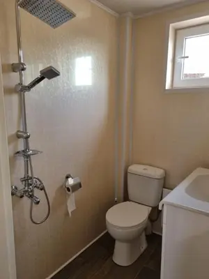 a bathroom with a toilet and a shower and a sink at Къща за гости ВИРА in Yasă-Koriya