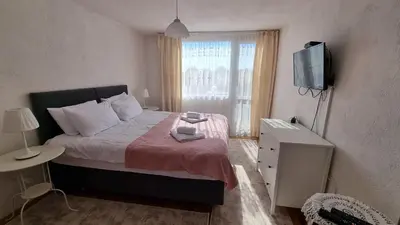 a small bedroom with a bed and a television at Къща за гости ВИРА in Yasă-Koriya