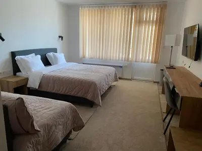 a hotel room with two beds and a desk at SUGARFAME- Guest House in Sarnitsa