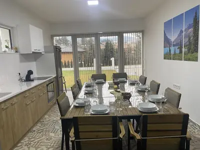 a dining room with a table and chairs in a kitchen at SUGARFAME- Guest House in Sarnitsa
