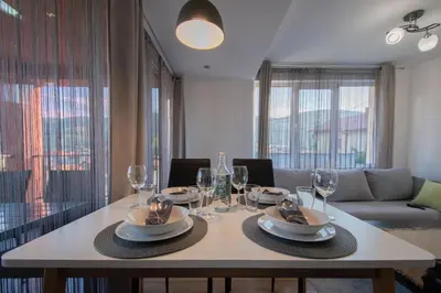 a dining room table with wine glasses and a couch at Hyggemate - 1 Bed Room Cozy Apartment in Sarnitsa in Sarnitsa