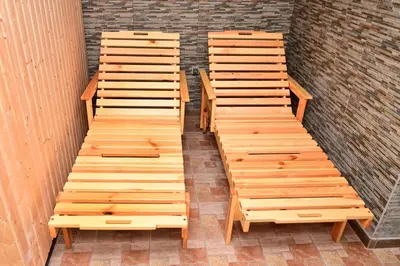a row of wooden benches sitting next to a brick wall at Ловна резиденция ДЛС Извора in Devin