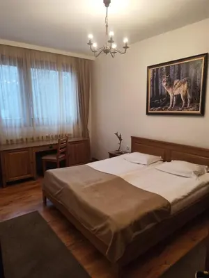 a bedroom with a bed and a painting of a wolf at Ловна резиденция ДЛС Извора in Devin