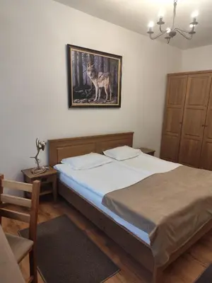 a bedroom with a bed with a picture of a wolf at Ловна резиденция ДЛС Извора in Devin