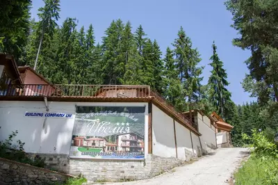 a sign on the side of a building at Ивелия Къща за гости in Dospat