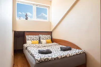 a bedroom with a bed with pillows and a window at Studio KFC in Sofia