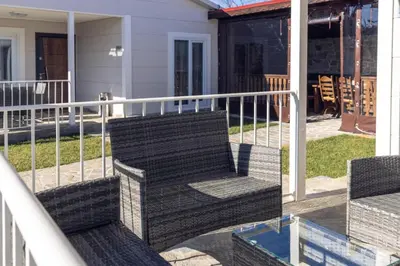 a porch with a bench and a railing at Къщи за гости 