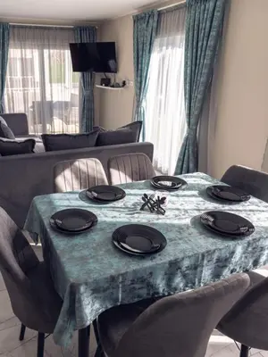 a dining room table with a blue table cloth and chairs at Къщи за гости 