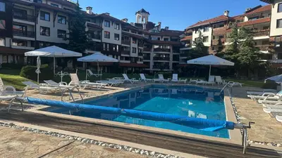 a large swimming pool with chairs and umbrellas at Eleonor Mountain Studio in Bansko