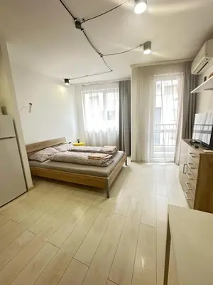 a bedroom with a bed and a wooden floor at Urban Nest 7 studio in Sofia