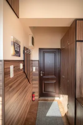 a hallway with a black door and wooden walls at Studio Subway in Sofia