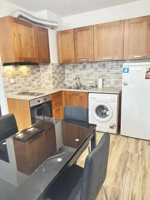a kitchen with wooden cabinets and a washer and dryer at Metropolitan Paradise & private parking in Sofia