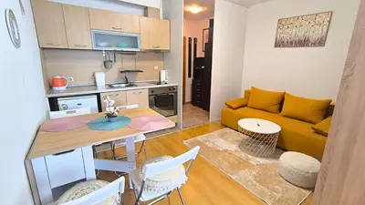 a living room with a yellow couch and a table at Cozy SPA Retreat with free Bottle of Wine in Aspen Golf in Razlog