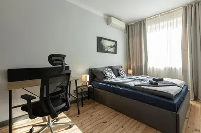 a bedroom with a desk and a bed with a desk at Downtown Stylish Flat in Sofia