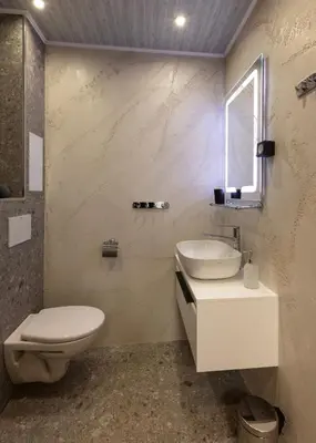 a bathroom with a toilet and a sink and a mirror at Downtown Stylish Flat in Sofia