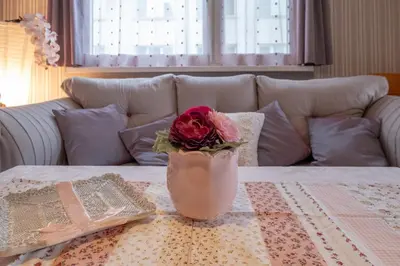 a vase with a rose in it sitting on a table at Little HoMe with a Park View by Flat Mаnager in Sofia