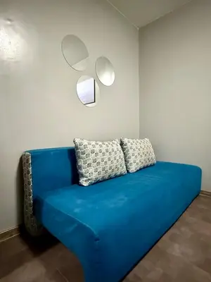 a blue couch in a room with two mirrors at Maxi studio & private parking included in Sofia