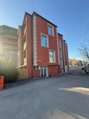 a red building on the side of a street at Maxi studio & private parking included in Sofia