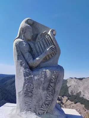 a statue of a woman playing an accordion at ADVENTURE apartments Trigrad in Trigrad