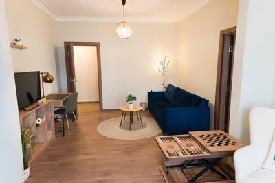 a living room with a blue couch and a tv at Artistic and cozy apartment in the center of Sofia in Sofia