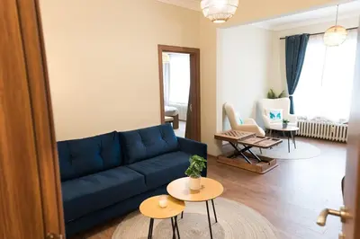 a living room with a blue couch and two tables at Artistic and cozy apartment in the center of Sofia in Sofia