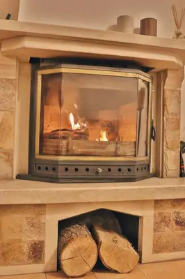 a stone fireplace with a fire in it at Gardenia Apartment Pamporovo in Pamporovo