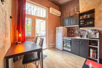 a small kitchen with a table and a refrigerator at Sofia's Gem Apartment - Prime Location in Sofia