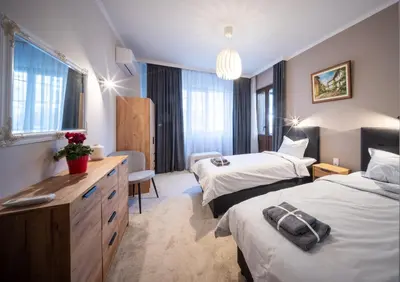 a hotel room with two beds and a desk at Top Centre Spacious 2 bedroom Apartment in Sofia