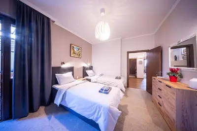 a bedroom with two beds and a sink and a mirror at Top Centre Spacious 2 bedroom Apartment in Sofia