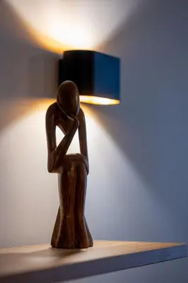 a wooden figurine of a woman sitting on a table with a lamp at Top Centre Spacious 2 bedroom Apartment in Sofia