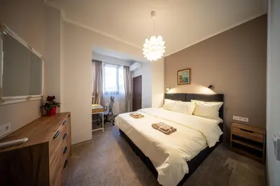 a bedroom with a large bed and a chandelier at Top Centre Spacious 2 bedroom Apartment in Sofia