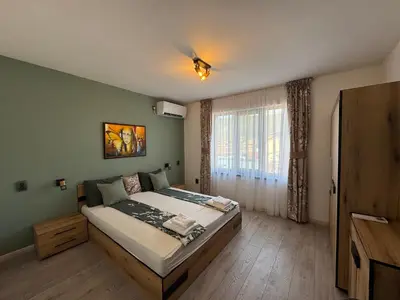 a bedroom with a bed and a large window at Kamberovi house Kalofer in Kalofer