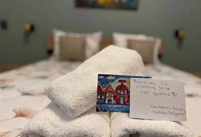 a pile of towels on a bed with a note at Kamberovi house Kalofer in Kalofer