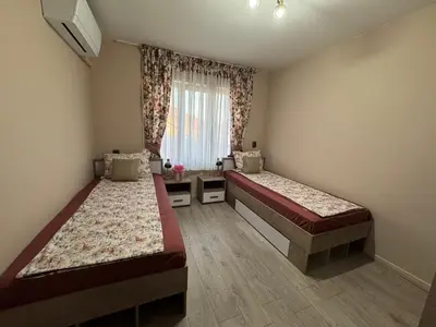 a bedroom with two beds and a window at Kamberovi house Kalofer in Kalofer
