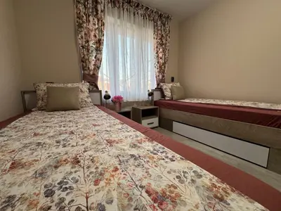 a bedroom with two beds and a window at Kamberovi house Kalofer in Kalofer