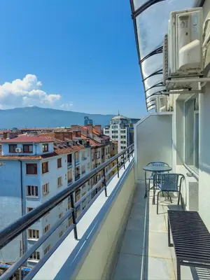 a balcony with tables and chairs on a building at Kolev Apartment 1 in Sofia