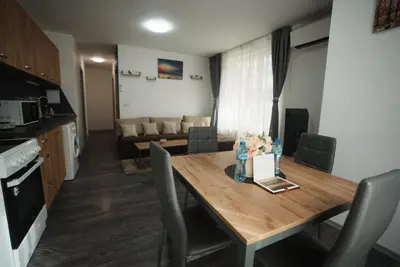 a kitchen and living room with a wooden table and chairs at Royal nest in Sofia