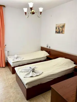 a hotel room with two beds and a chandelier at Trigrad hills in Trigrad