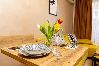 a dining room table with plates and flowers on it at Central Lovely apartment Venu close to Old Town in Plovdiv