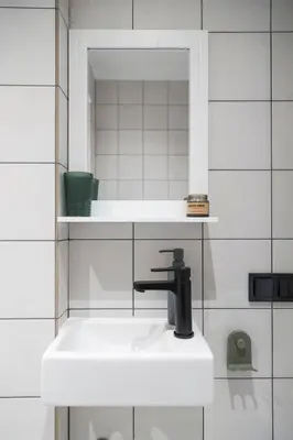 a white bathroom with a sink and a mirror at Quiet Elegance in Sofia Center in Sofia